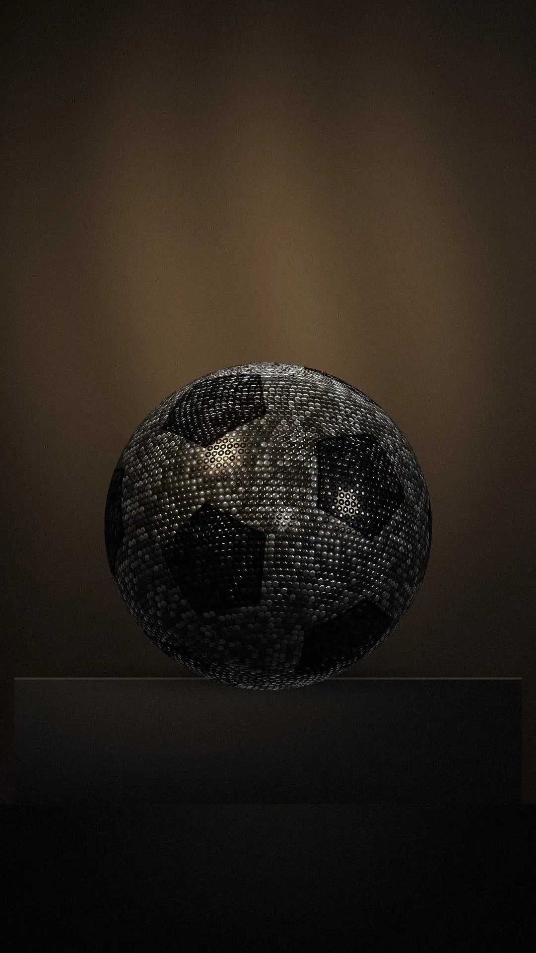 The BLIZAZZ Soccer ball on a stone plinth under a single lamp