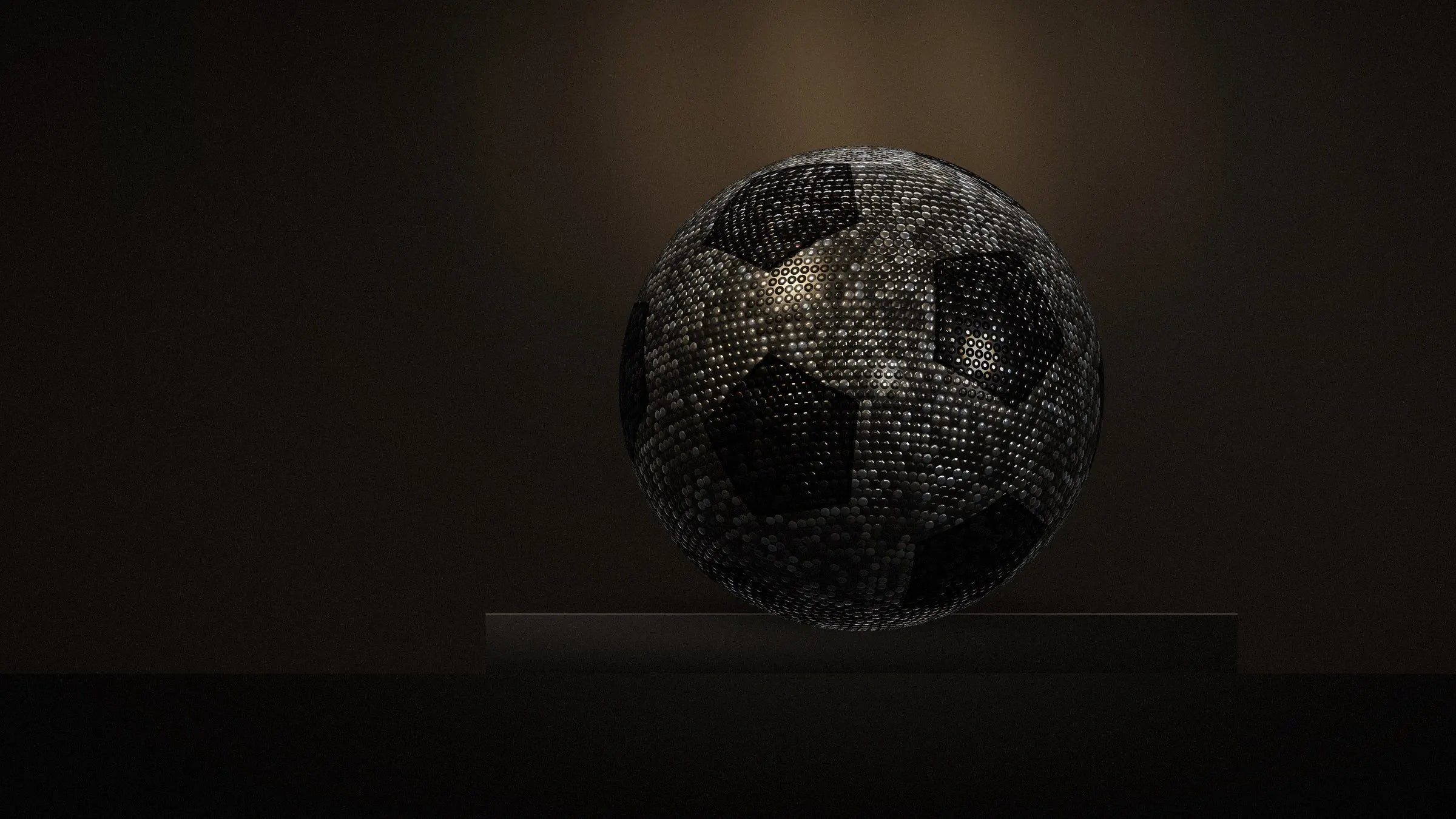 The BLIZAZZ Soccer ball on a stone plinth under a single lamp